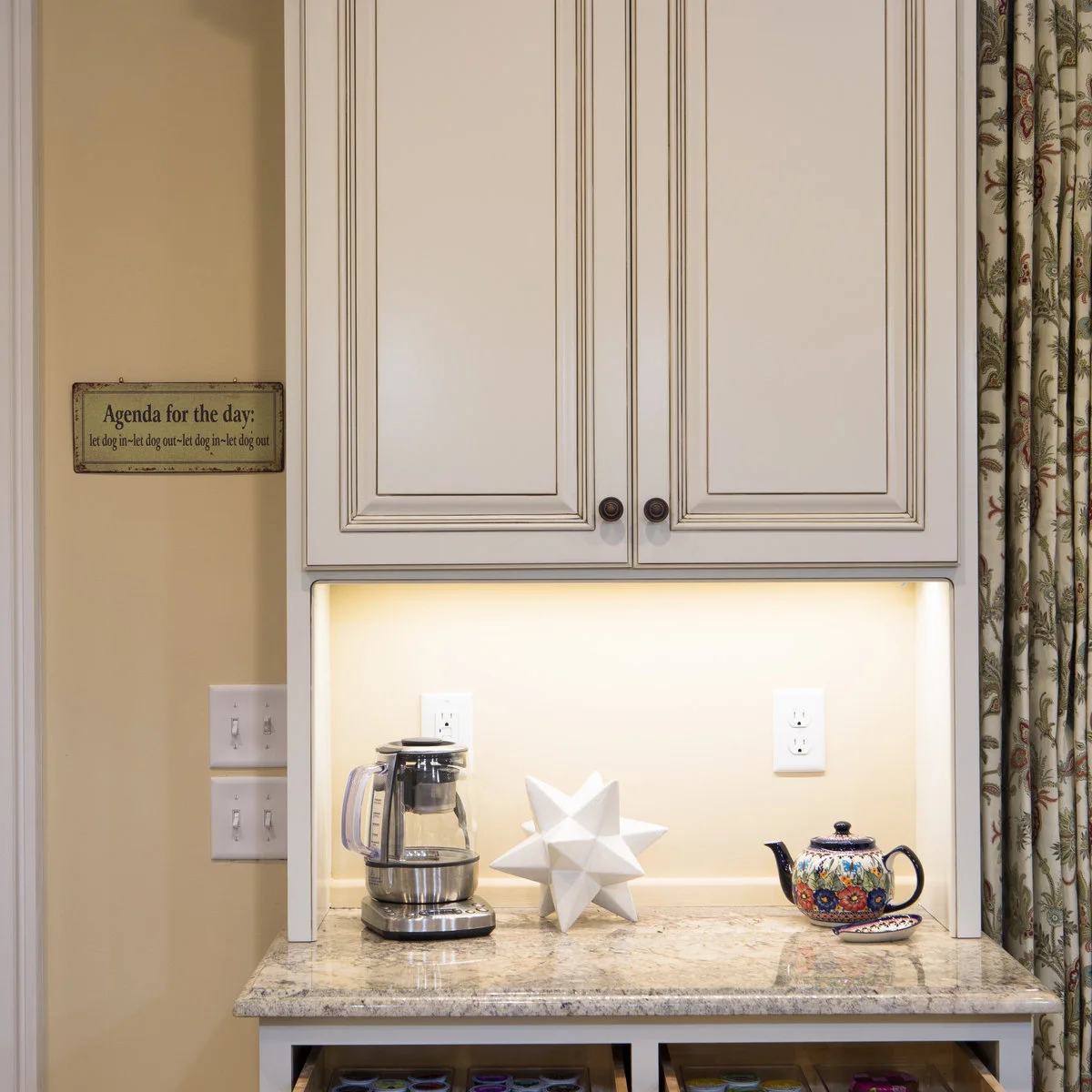 Pale coffee counter with under-cabinet lighting, glass brewer and patterned teapot