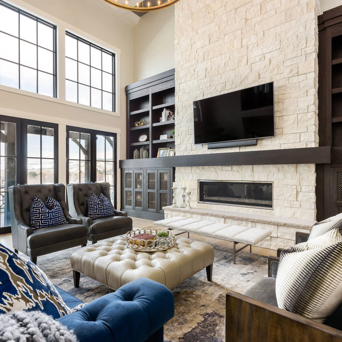 A television and long dark mantel on a tall pale block fireplace wall beside dark built-in cabinets.