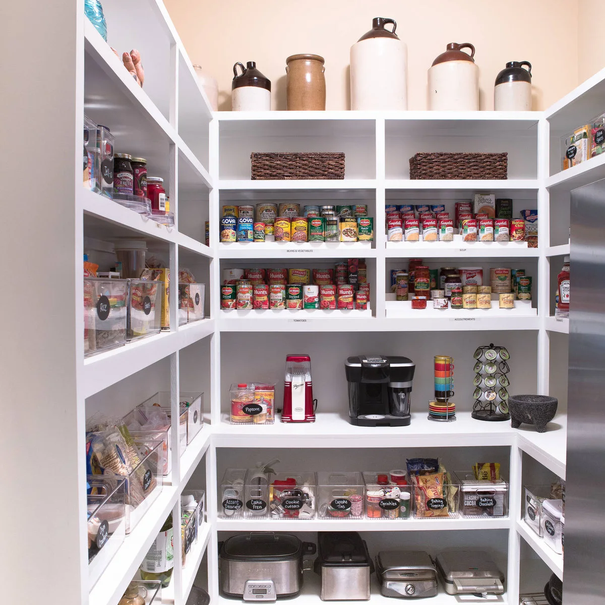 Pantry with canned foods grouped on labeled shelves and small packets in clear bins