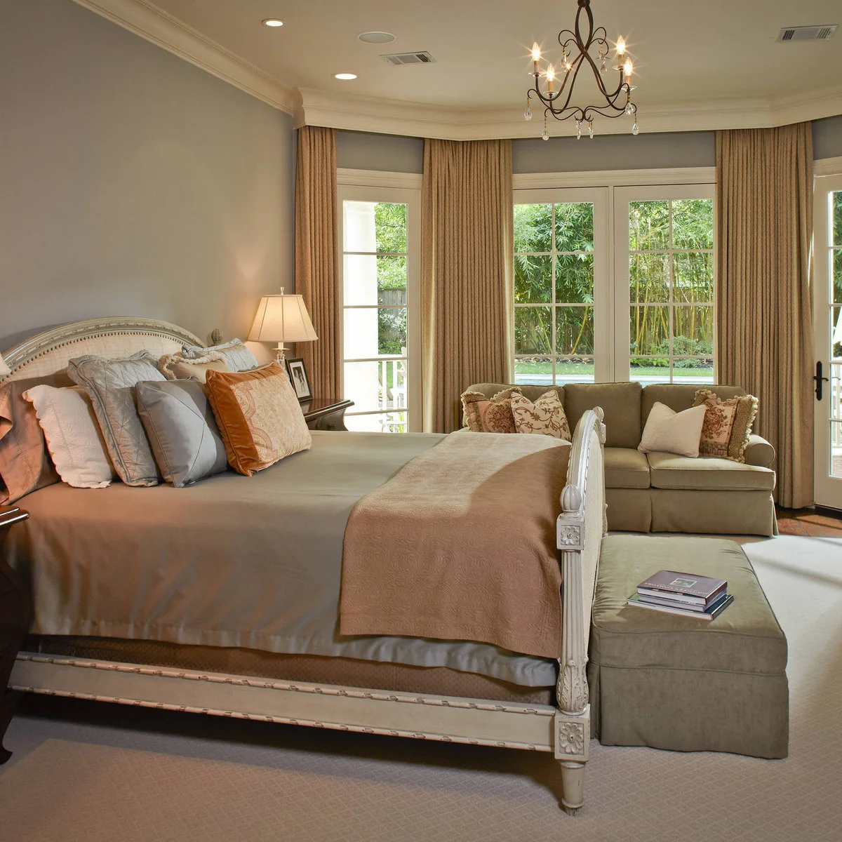 Warm gray bedroom walls with cream window trim, pale upholstered furniture and muted pink bedding.