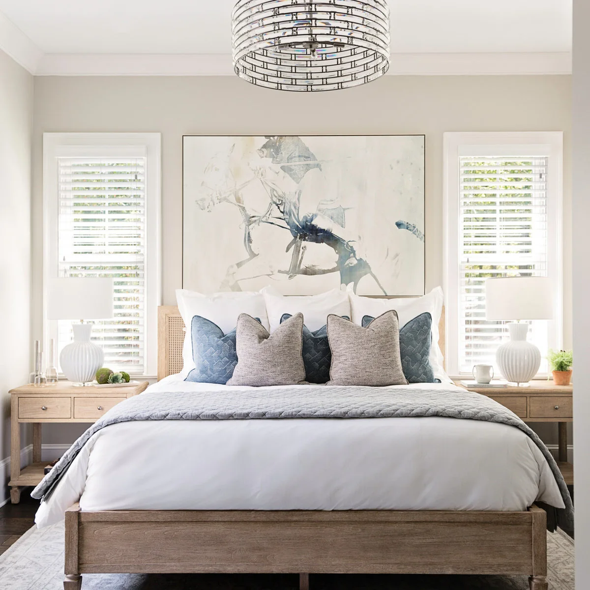 Broad pale horse drawing above a wood-framed bed between shuttered windows with white bedside lamps.