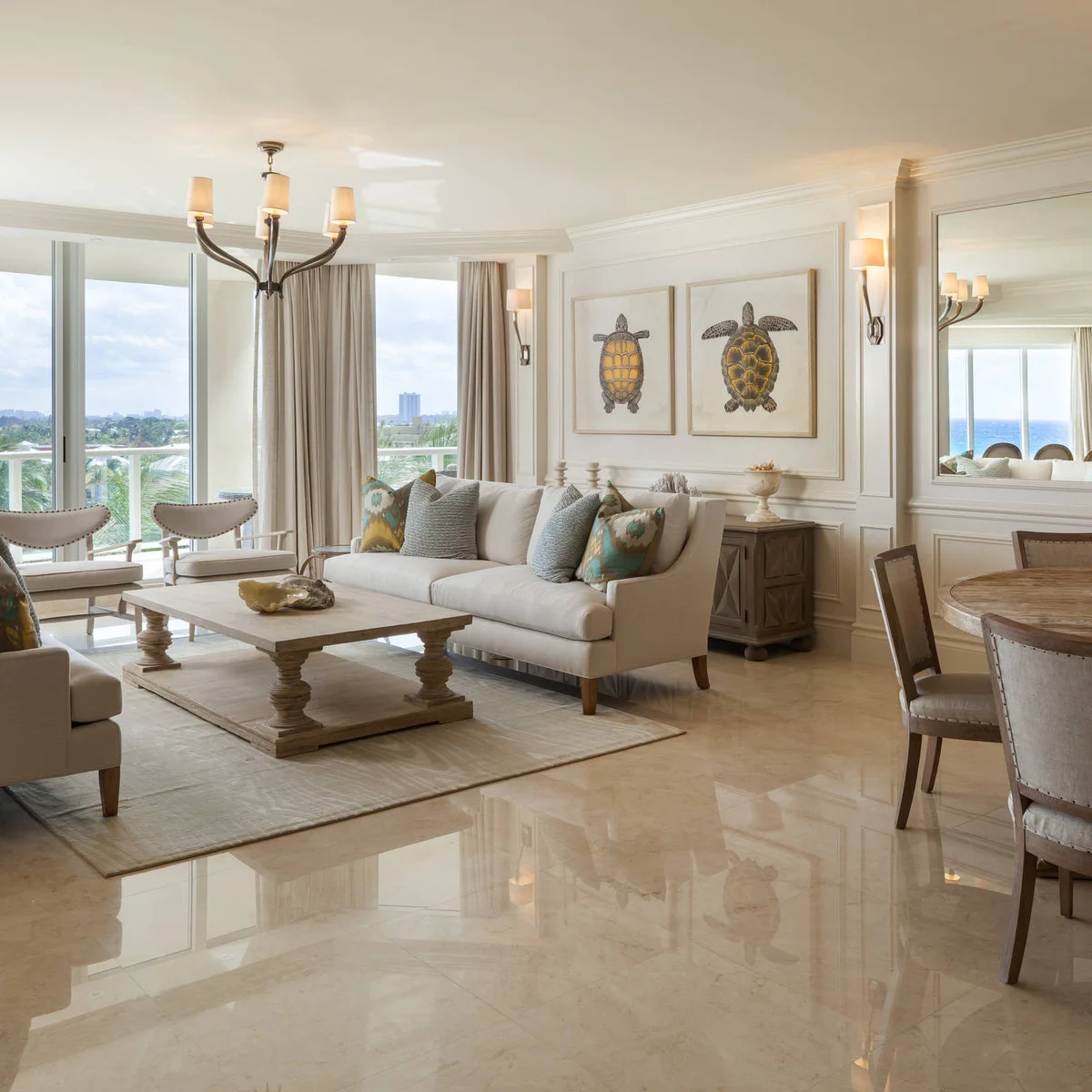 A pale living room group sits on a rectangular rug beside a dining table, with an open strip of floor between them.