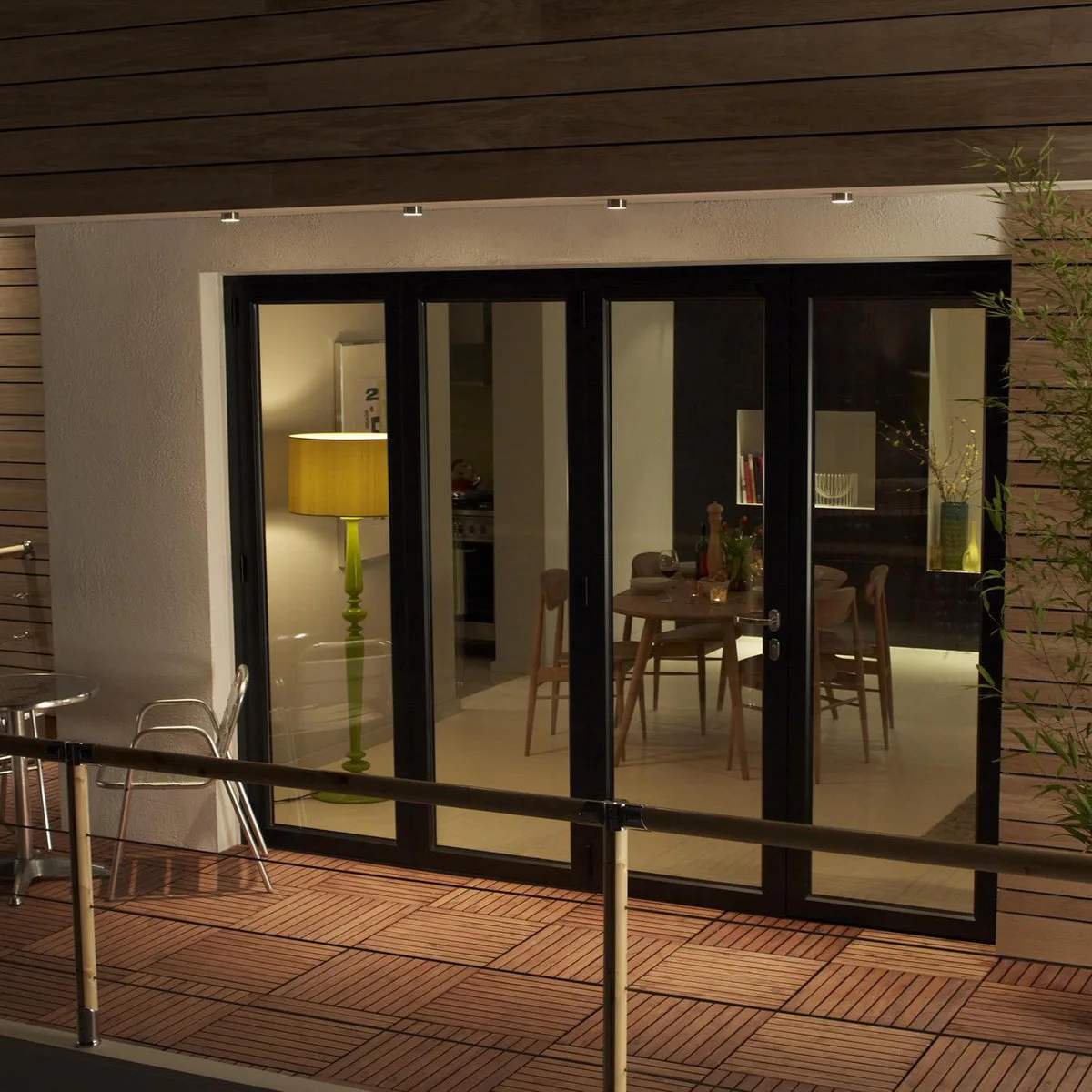 Apartment balcony with square wood-colored floor tiles outside wide glazed doors
