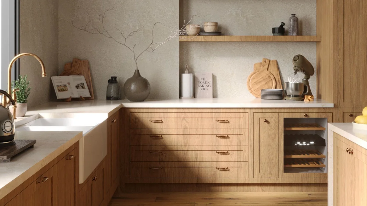 A wooden kitchen corner has a deep white sink, drawers, a narrow open shelf, pale counter and mixer beside cutting boards and vessels