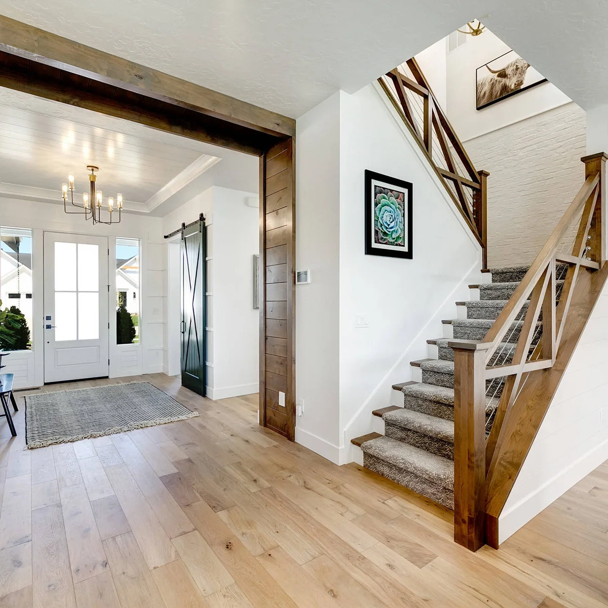 White brick forms a landing backdrop above a staircase with a gray runner and wood rail.