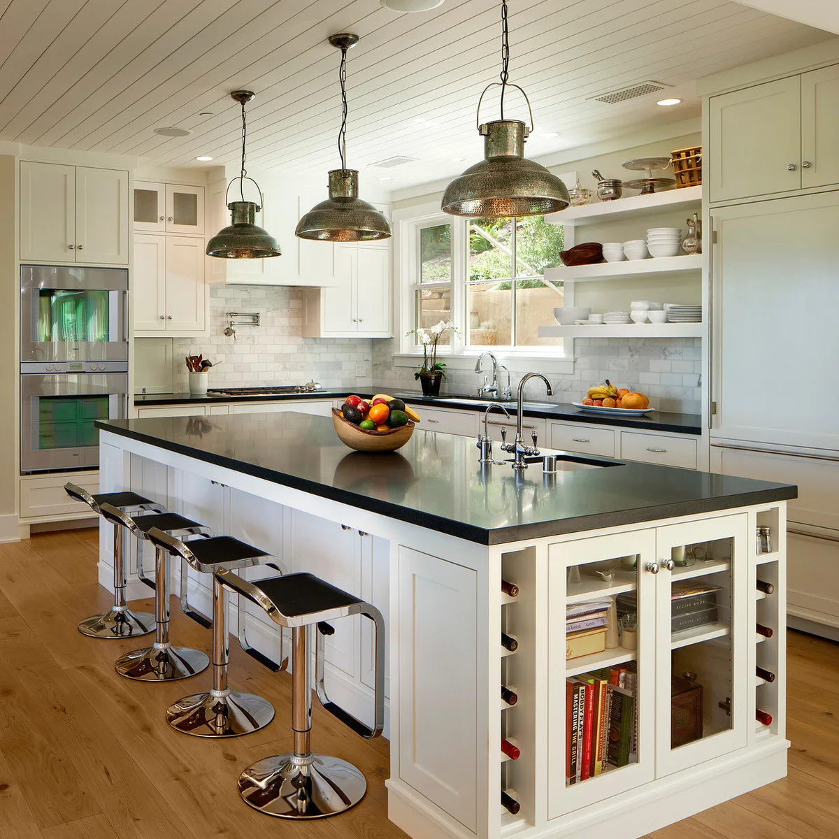 White kitchen island with glass-front end storage and slim bottle slots