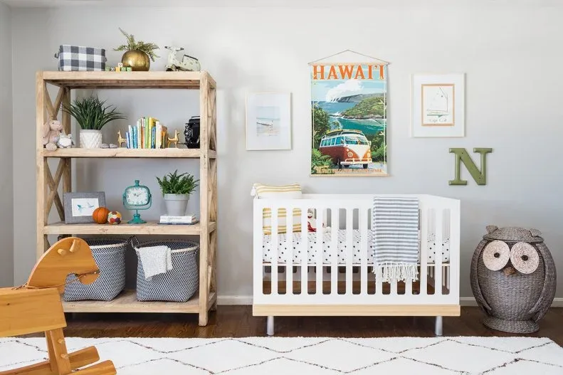Nursery with white crib, open wood bookcase, basket storage, owl-shaped hamper and wood rocking horse