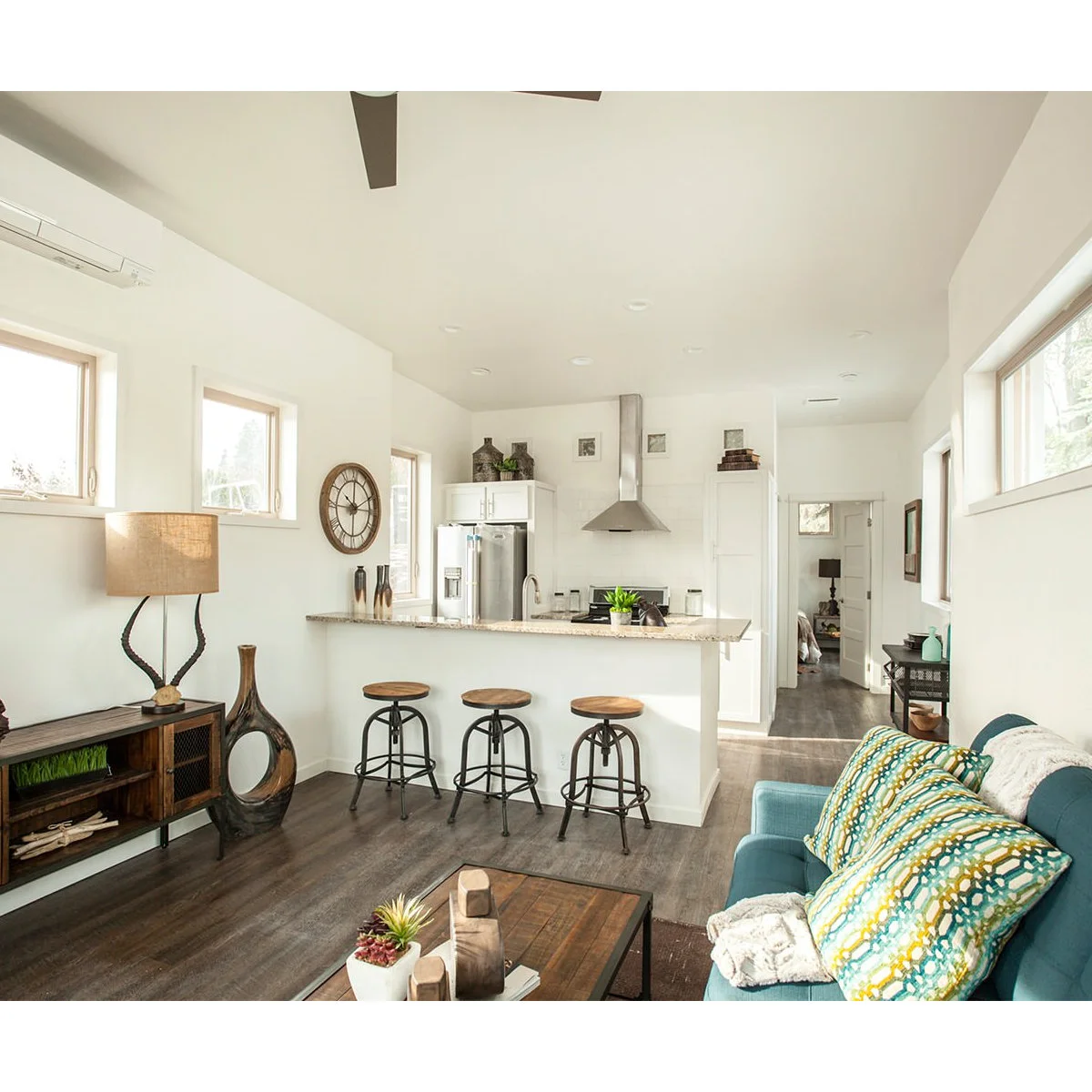 Small open living area with white walls and kitchen cabinets behind a blue sofa