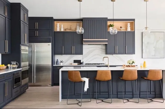 Navy upper cabinets include timber-lined display sections above a pale counter and matching island.