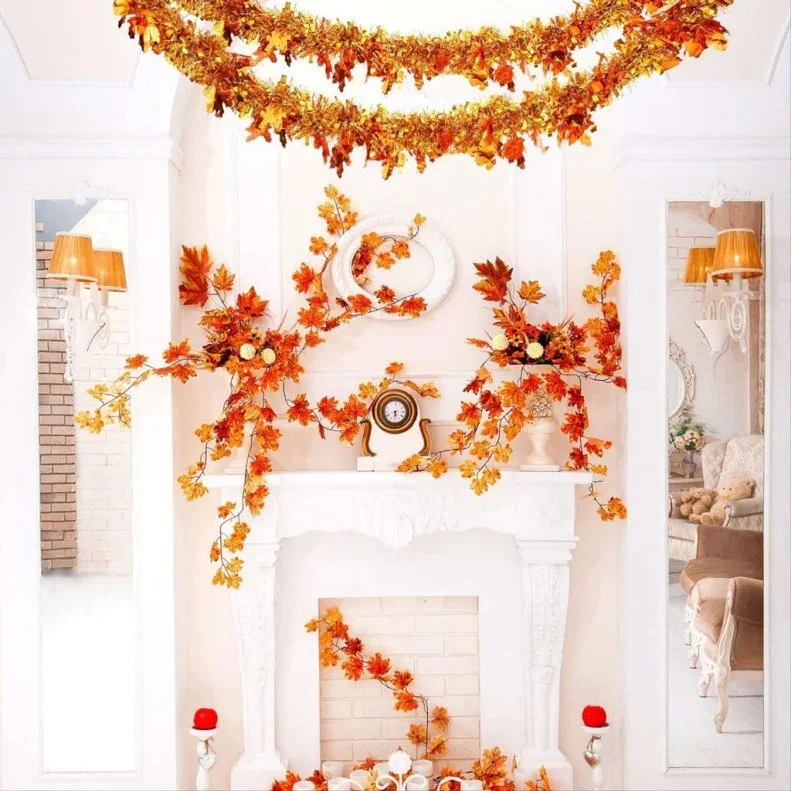 Warm orange garlands hang in layered curves and surround a pale fireplace and mantel beneath a round mirror
