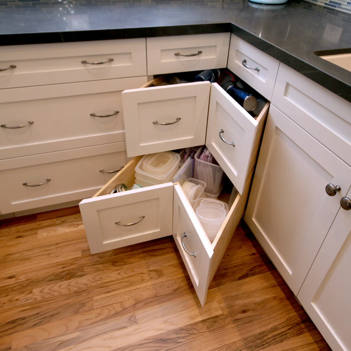 White angled corner drawers with food containers and lids in separate sections