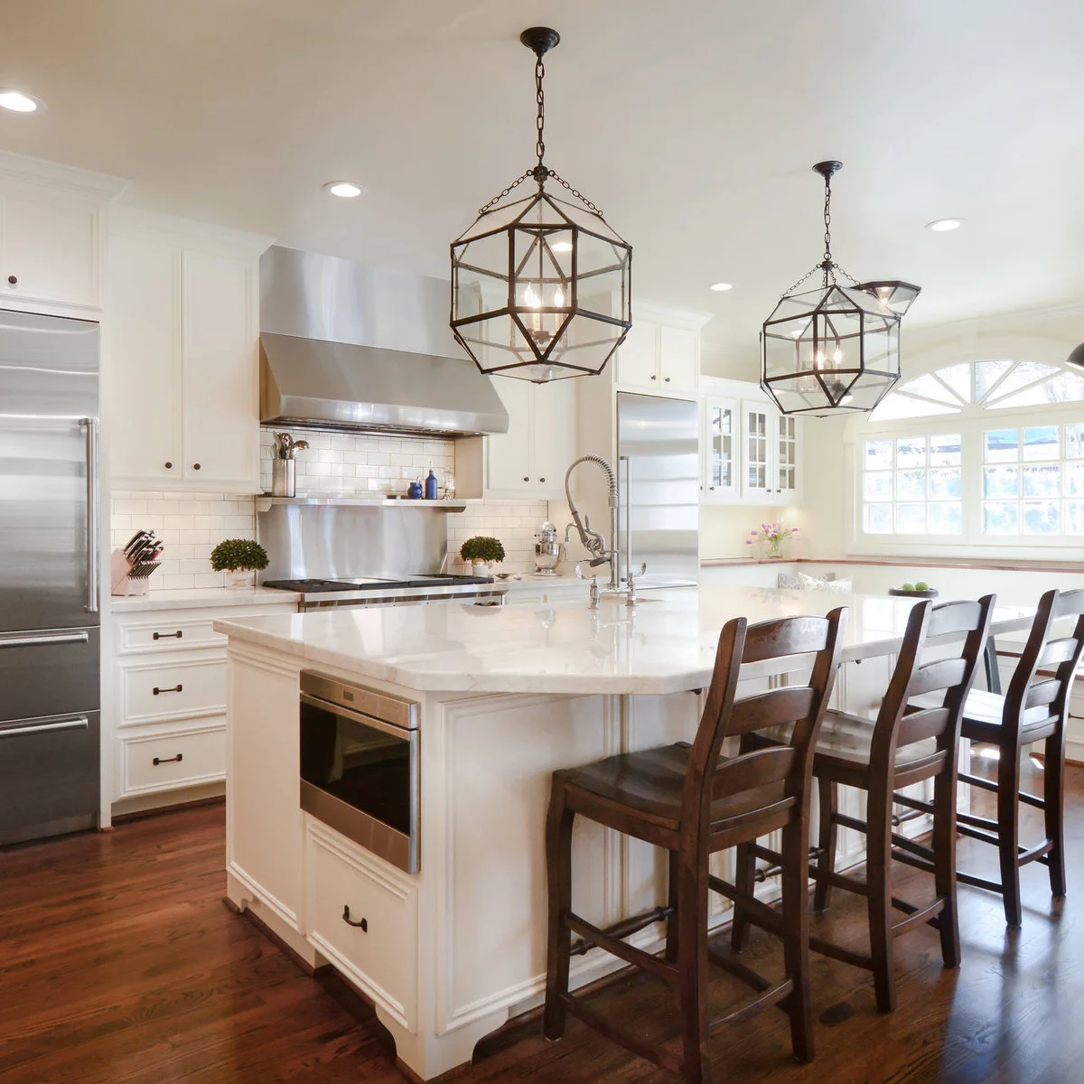 Wood kitchen stools with horizontal ladder backs and square seats beside a pale island