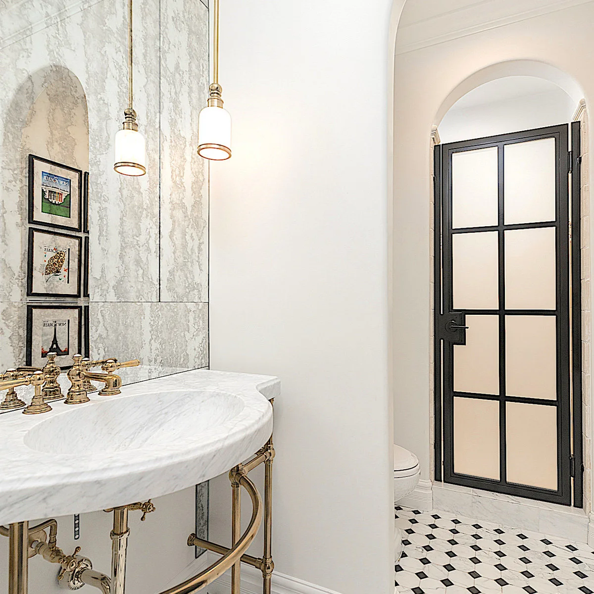 Broad mirror above a curved white bathroom basin with gold-colored fittings