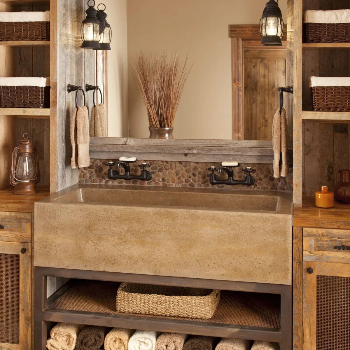 Dark towel rings are fixed to wood uprights at either end of a broad trough sink with two wall-mounted faucets.