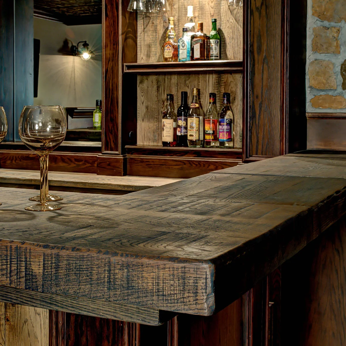 Close view of wood-colored bar counter with visible grain and bottle shelves behind