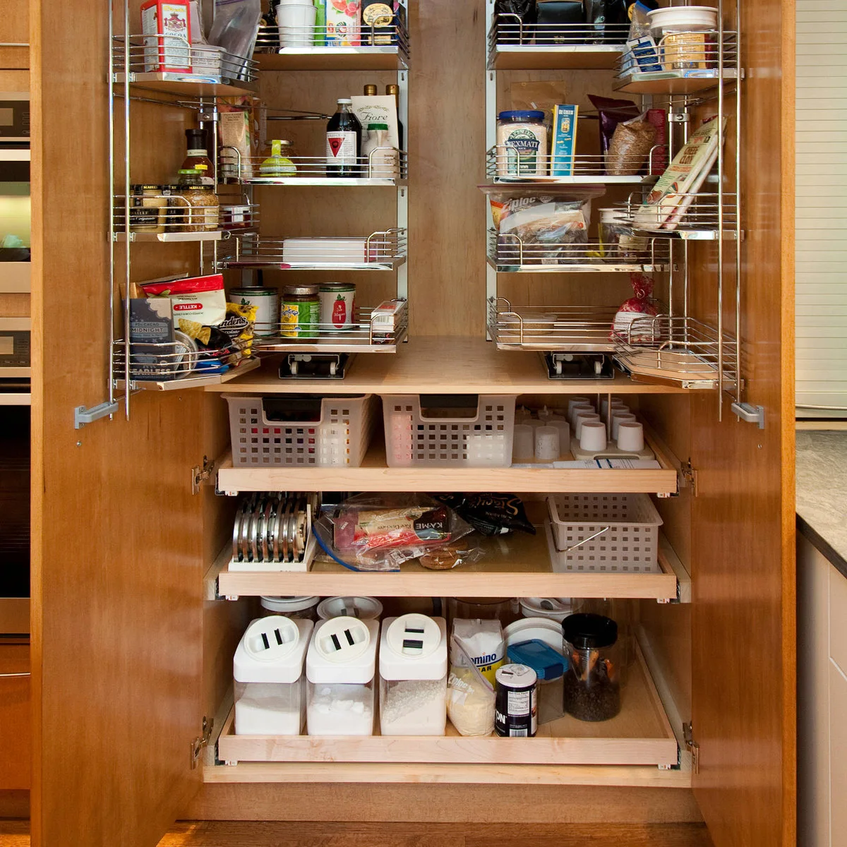 Wood pantry cupboard with lower pull-out trays beneath swing-out wire racks