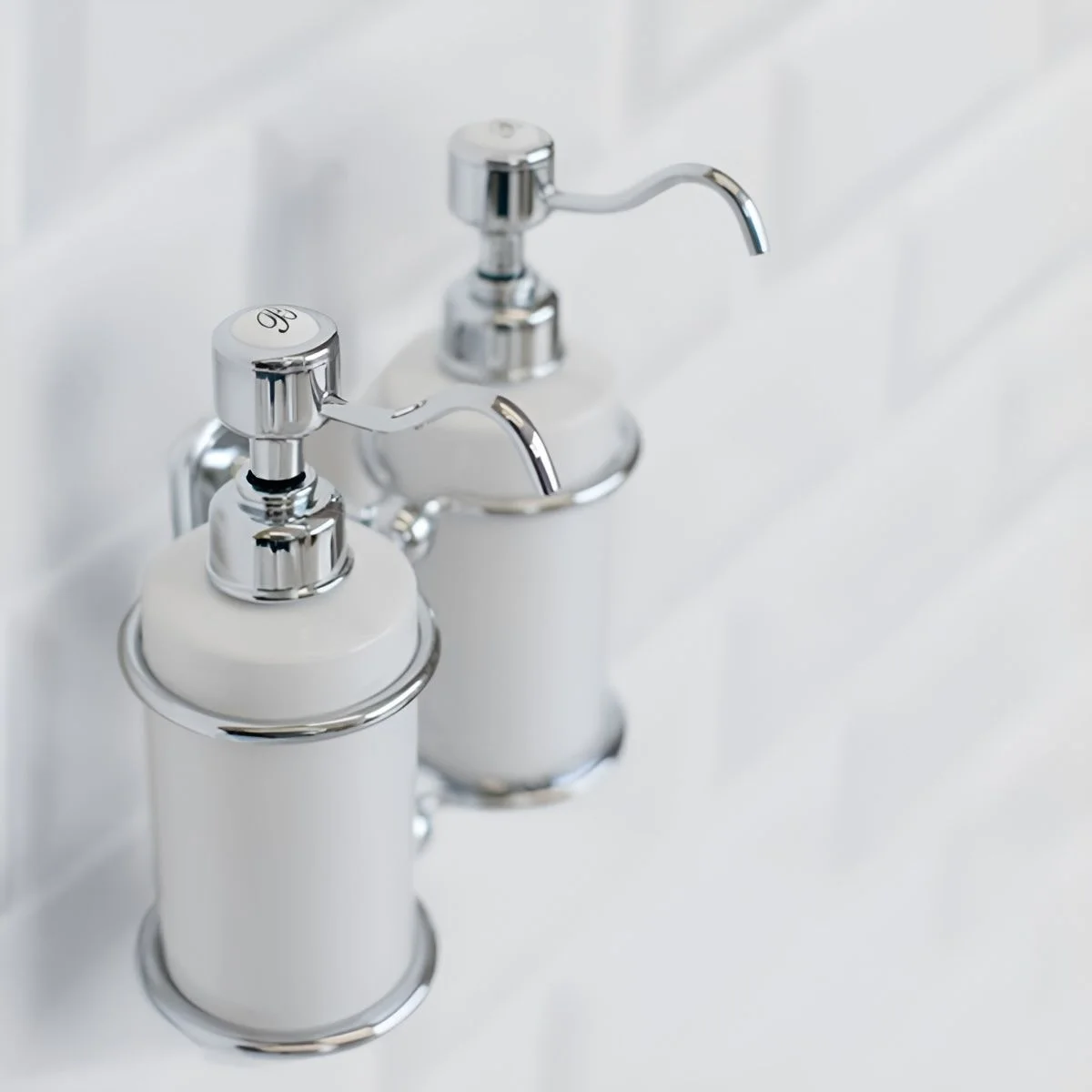 Two refillable white pump dispensers in wall-mounted metal holders