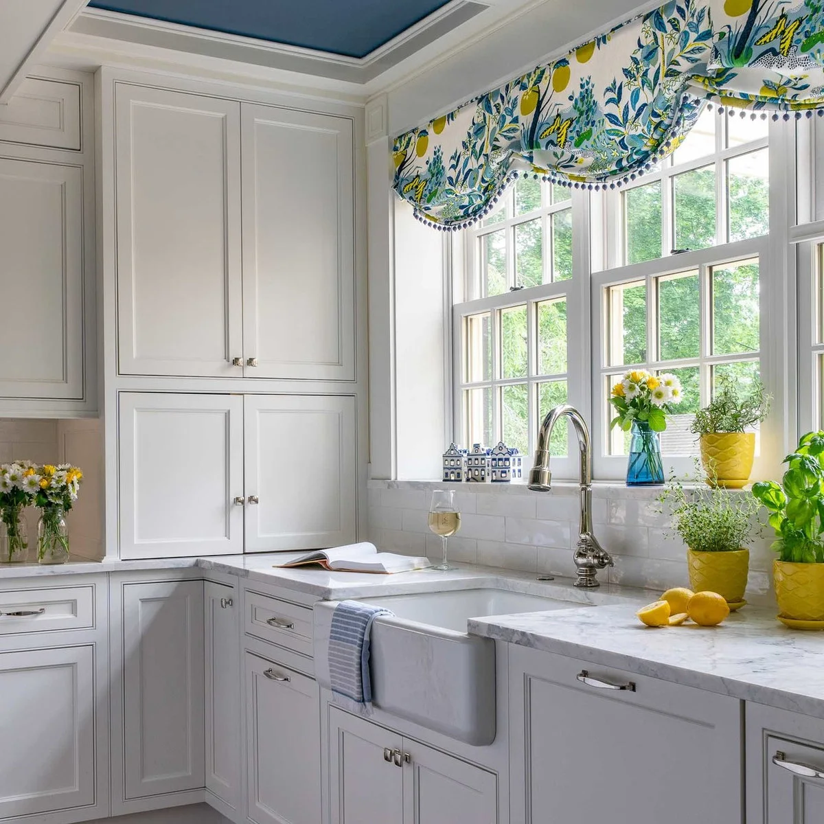 Blue, green and yellow patterned valance above a white kitchen sink window
