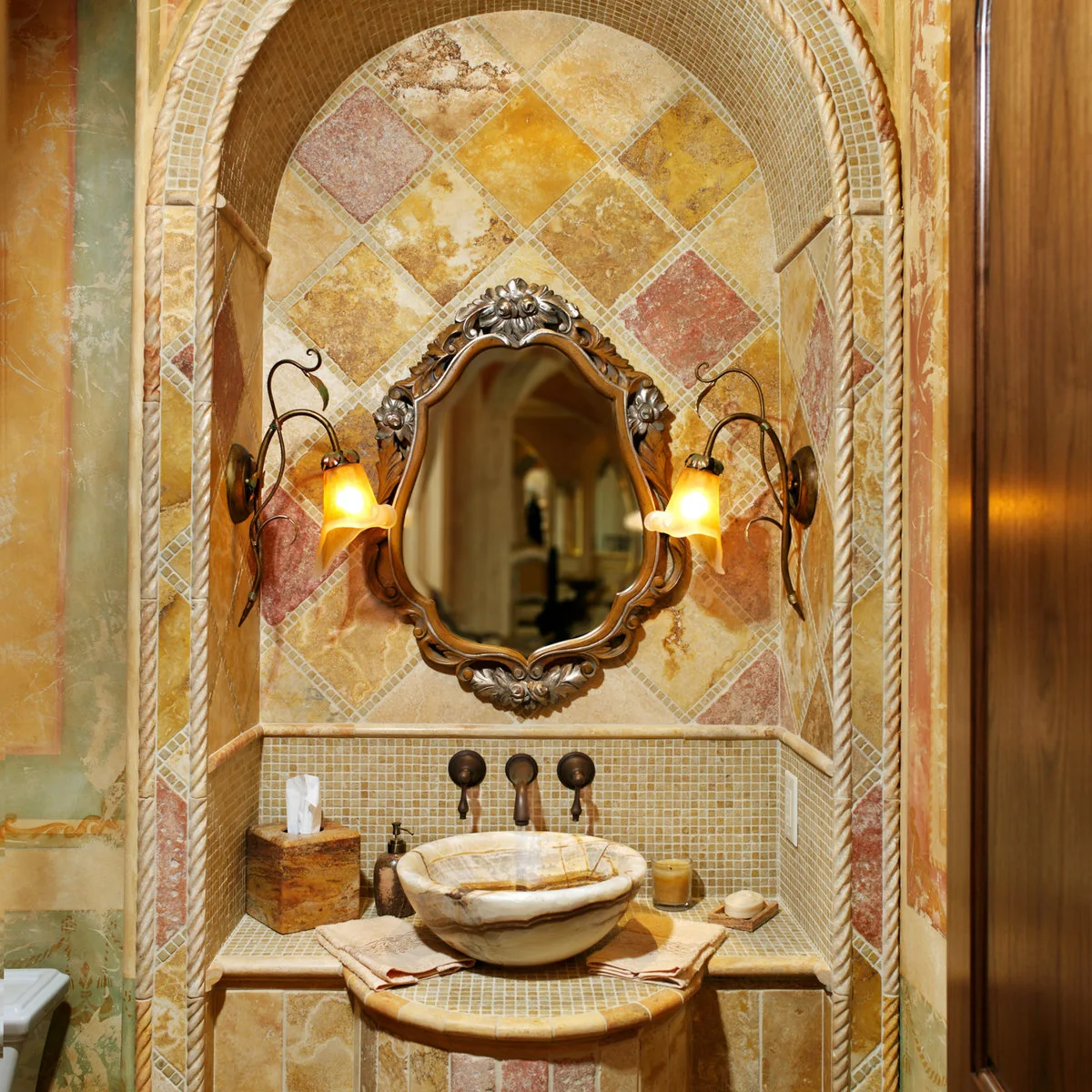 Ornate bathroom vanity alcove with warm diagonal tiles, tiny mosaic backsplash and a vessel basin