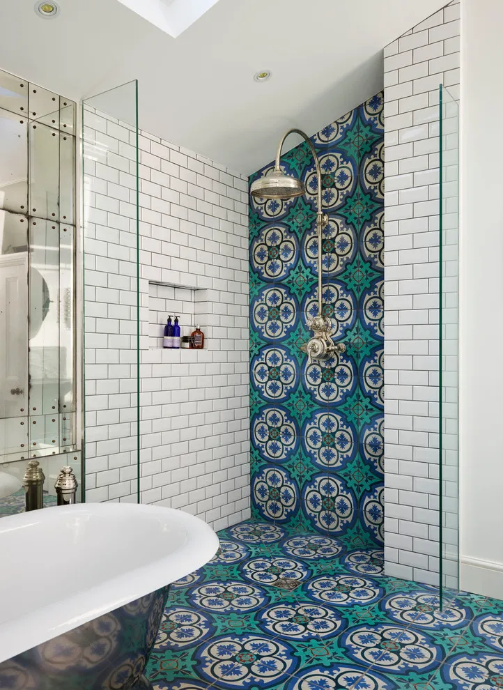 Blue and green patterned tiles cover the floor and continue onto the shower’s back wall