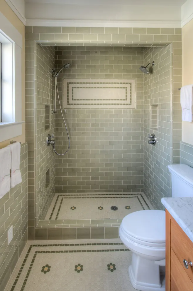 A pale mosaic shower floor contains small decorative motifs and a narrow border