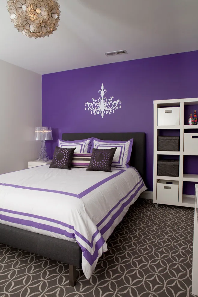 A purple accent wall stands behind a dark bed with white and purple striped bedding