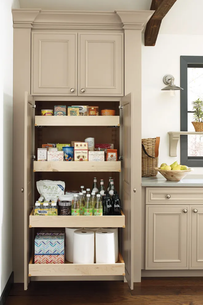 A tall taupe pantry cabinet opens to reveal shallow shelves and pull-out storage