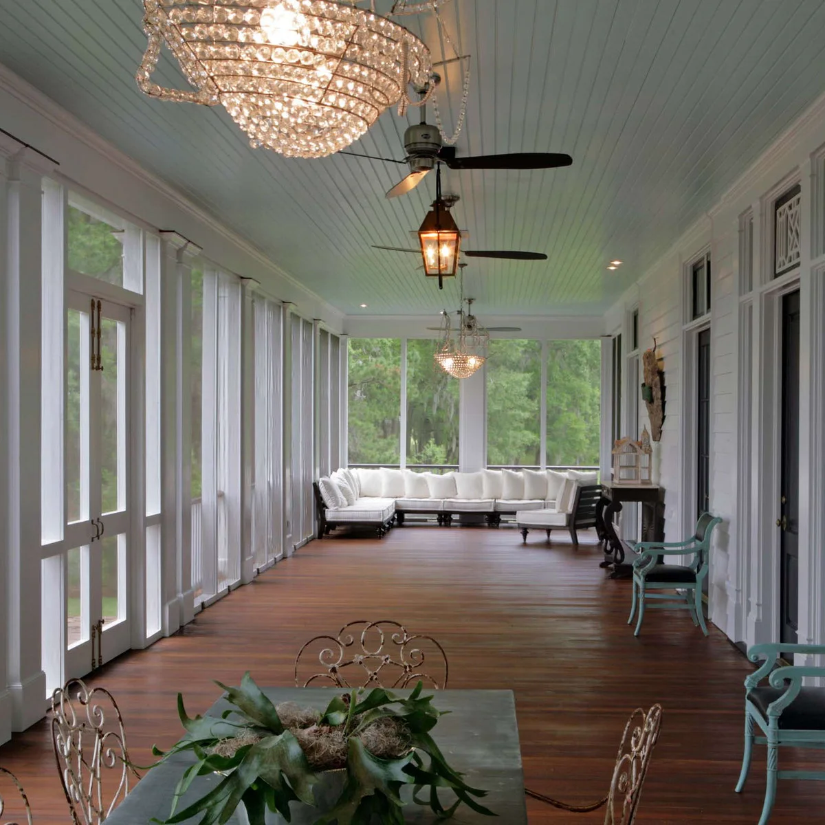 Pale blue grooved ceiling above a long screened porch with white seating