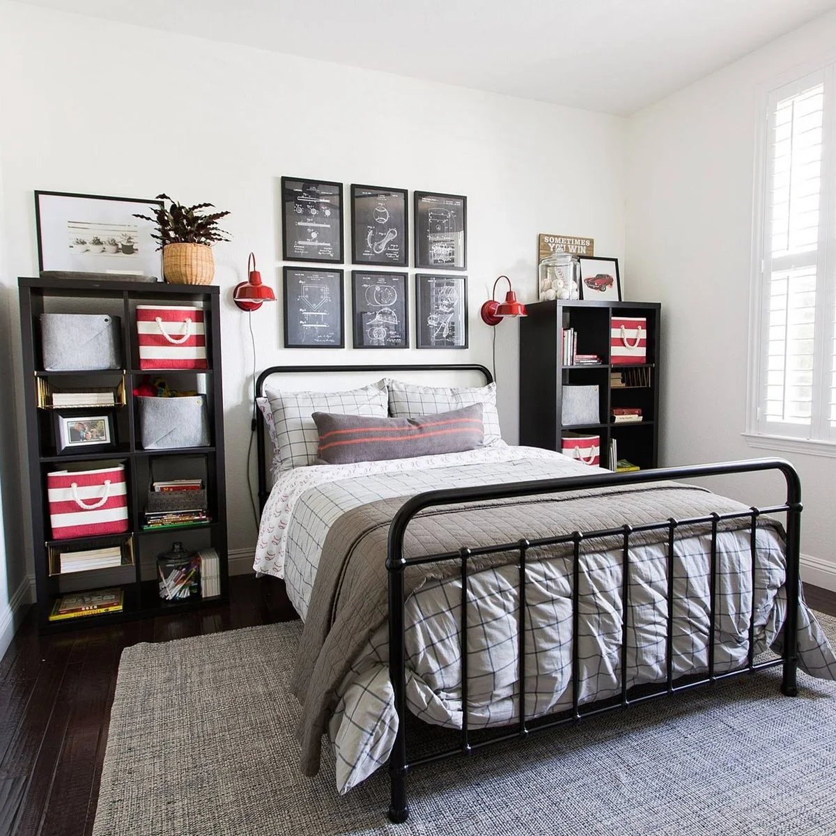 Teen bedroom with two dark cubby towers, red lamps and a black metal-looking bed