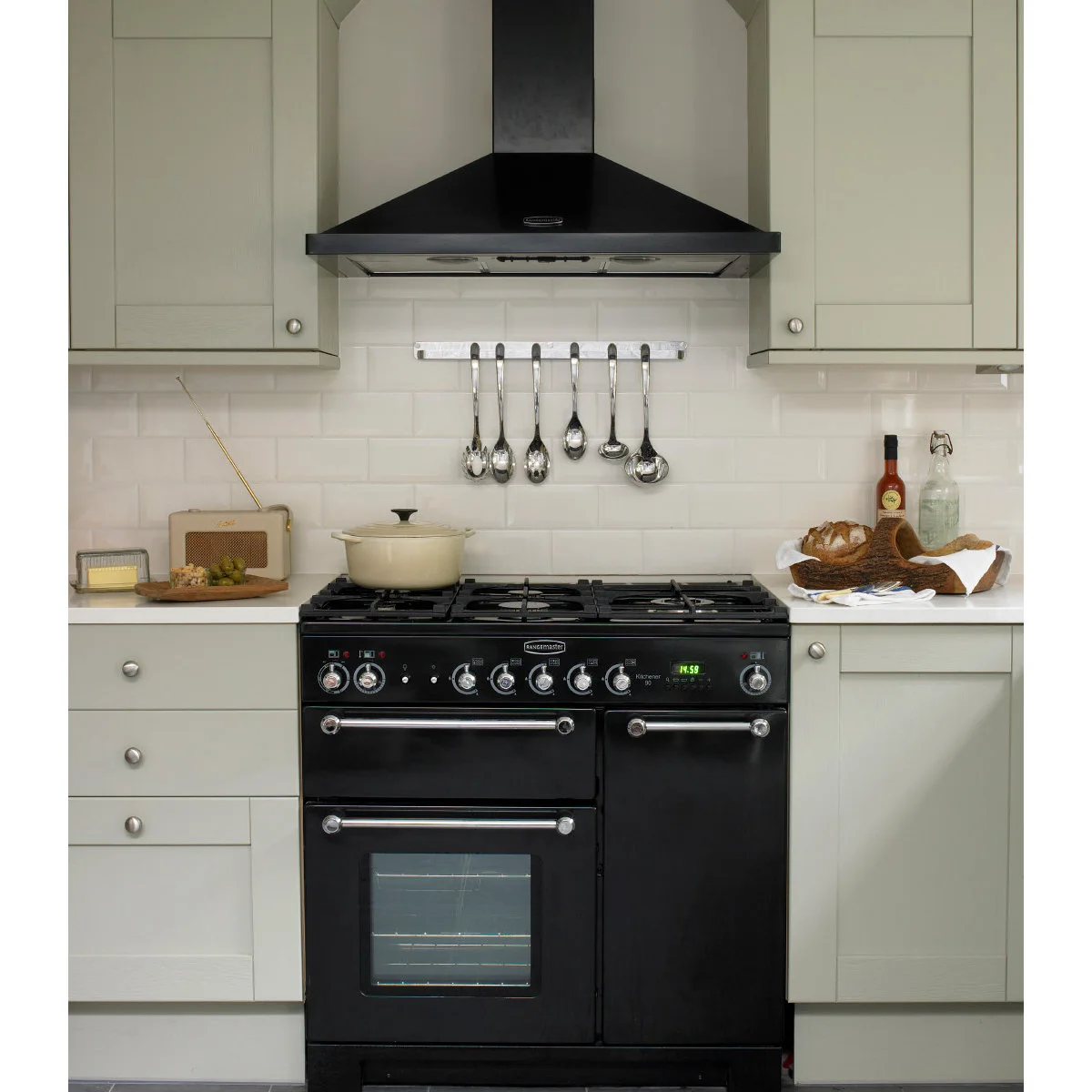 Victorian terraced-house kitchen with a black range, black hood and pale surrounding cupboards