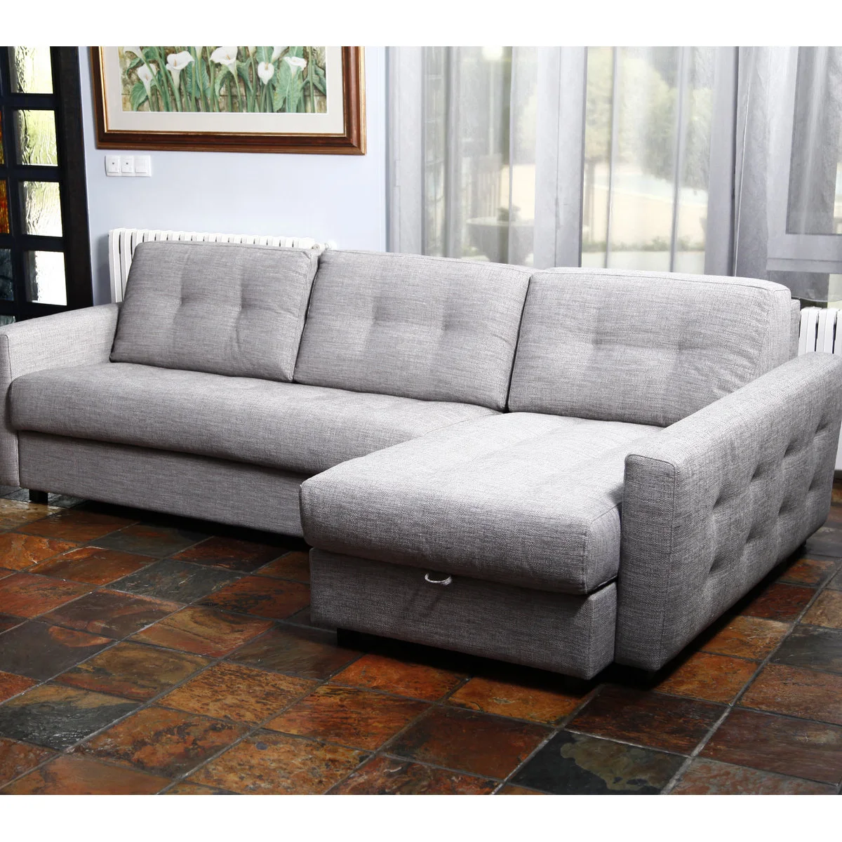 Gray sectional sleeper sofa with a right-hand chaise and a pull handle below the chaise cushion