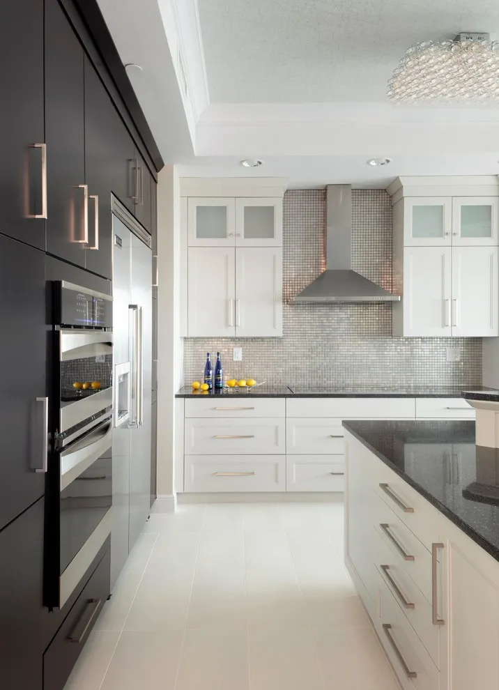 A dark tall cabinet wall stands beside white lower and upper cabinets in a narrow kitchen