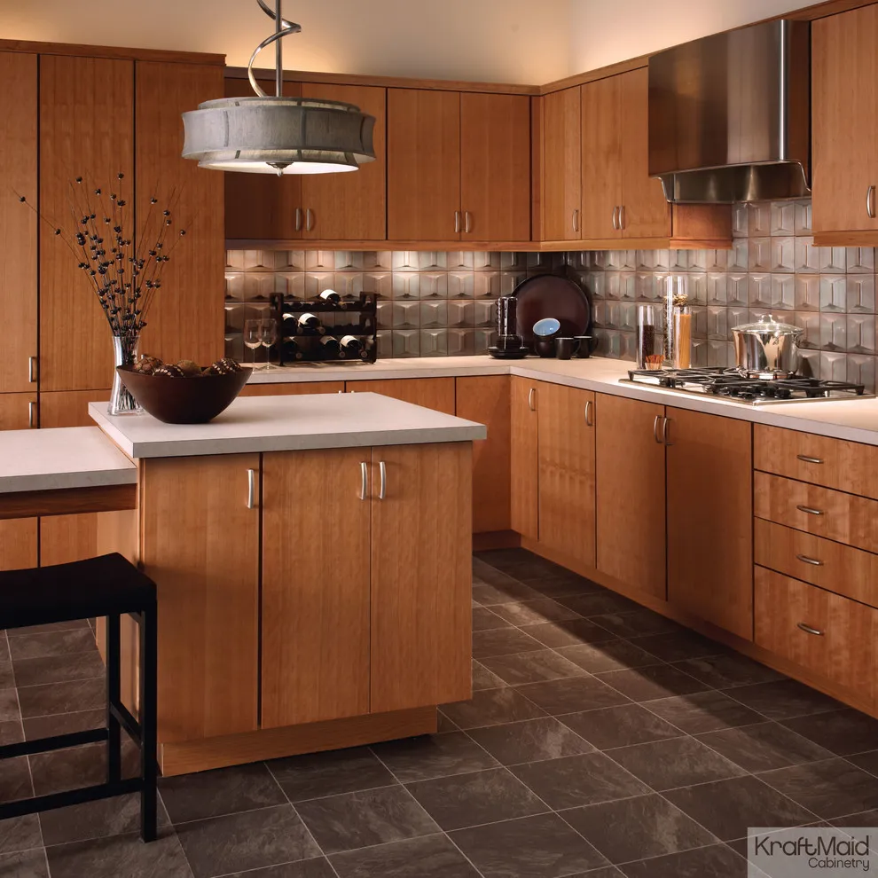 Warm wood cabinets with simple fronts sit beside a textured backsplash and pale peninsula