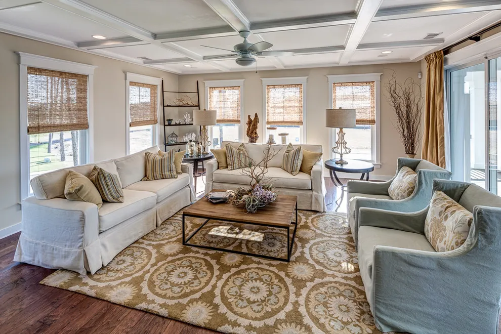 A pale sofa faces light blue chairs across a patterned rug and dark table