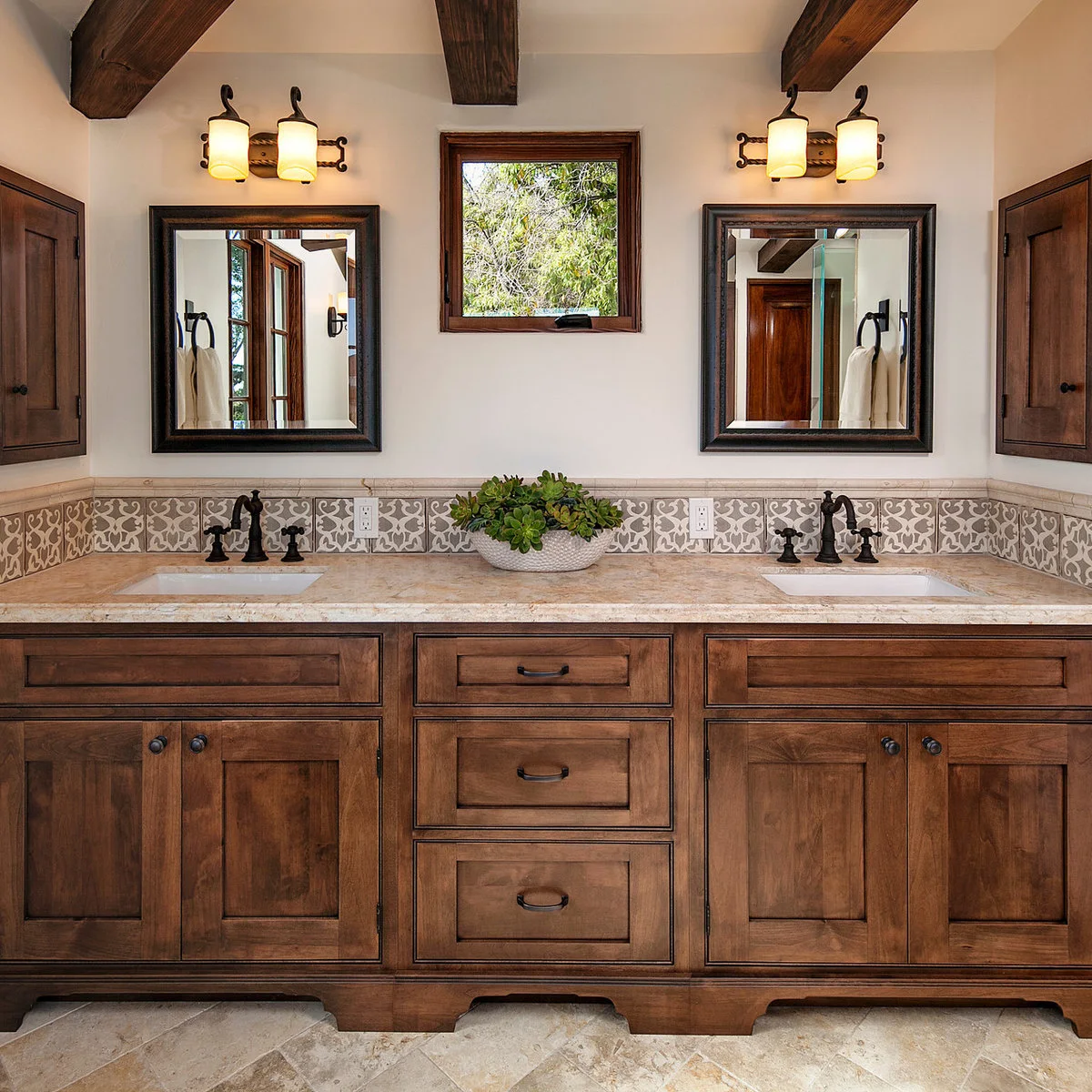Wood double vanity with a grey-and-white patterned tile backsplash, dark mirrors and exposed beams