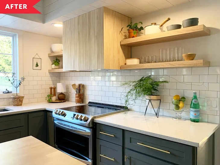 Renovated boho farmhouse kitchen with muted green cabinetry, natural wood open shelving and white subway tile