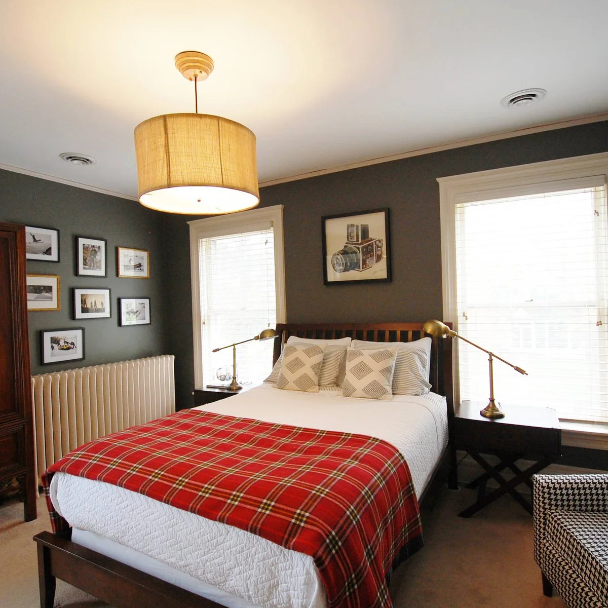 Gray teen bedroom with a photo gallery, red checked throw and adjustable bedside lamps