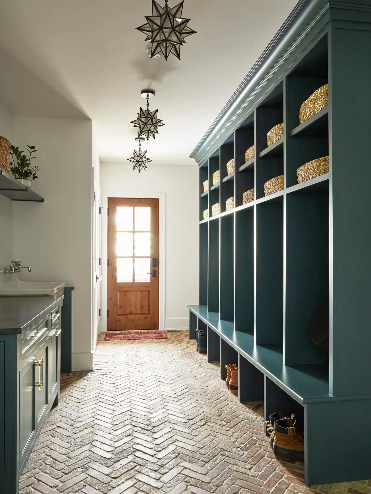 Deep-colored built-in storage lines an entrance above a patterned brick-style floor.