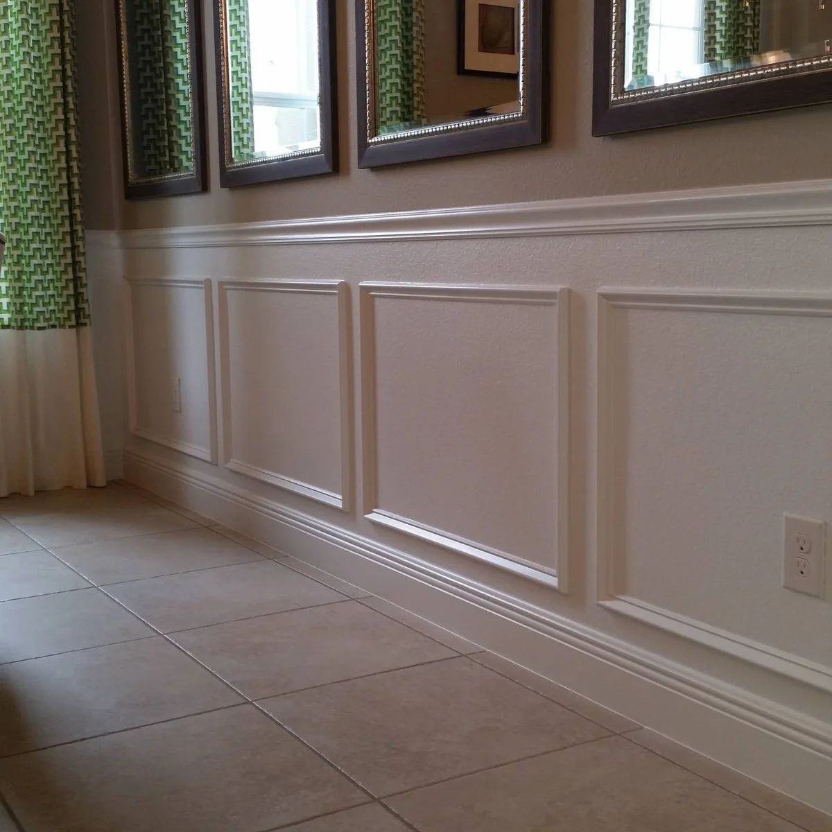White rectangular applied moldings on a lightly textured lower wall beneath mirrors