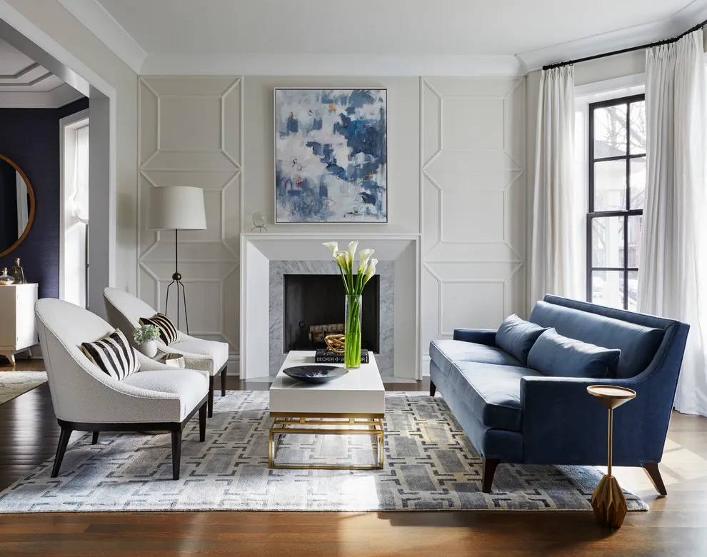 Light wall panels surround a fireplace beneath a blue abstract picture