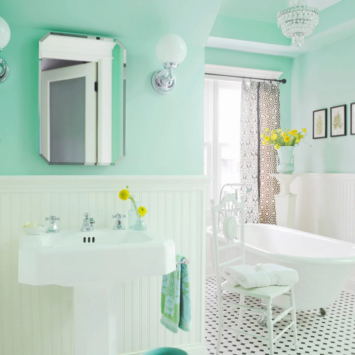 Mint walls rise above white beadboard beside a console basin, freestanding white bath, patterned floor and small white chair.