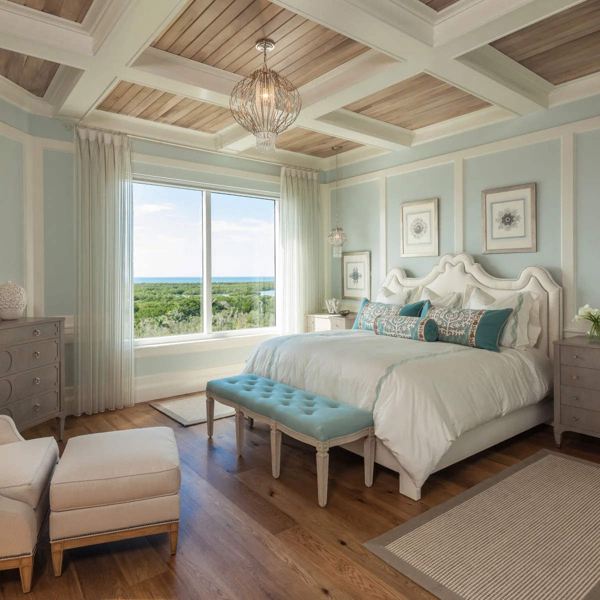Turquoise tufted bench on pale legs beneath a blue-and-white bedroom scheme