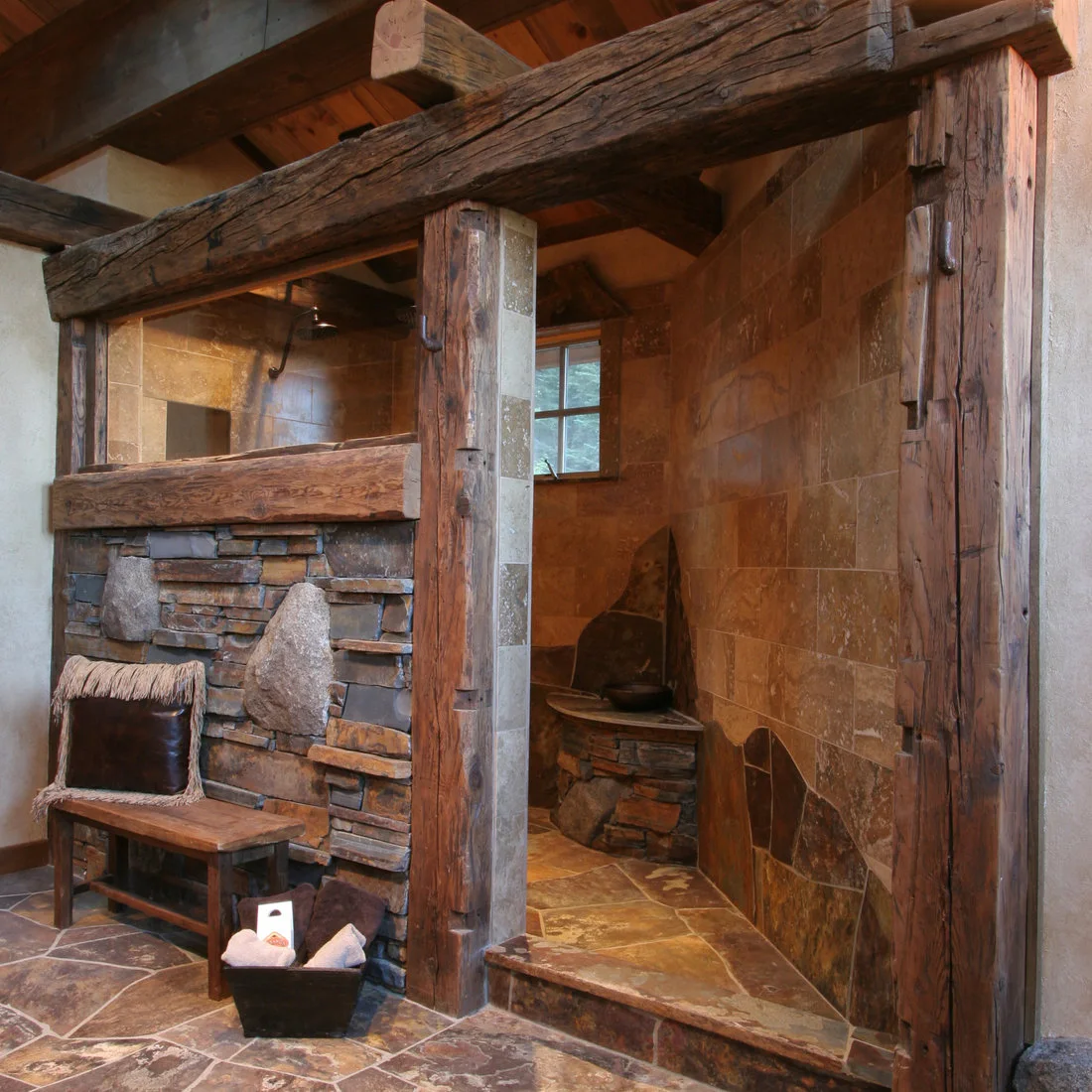 A doorless shower framed by substantial weathered timber and textured masonry, with warm wall tile and a raised entry.