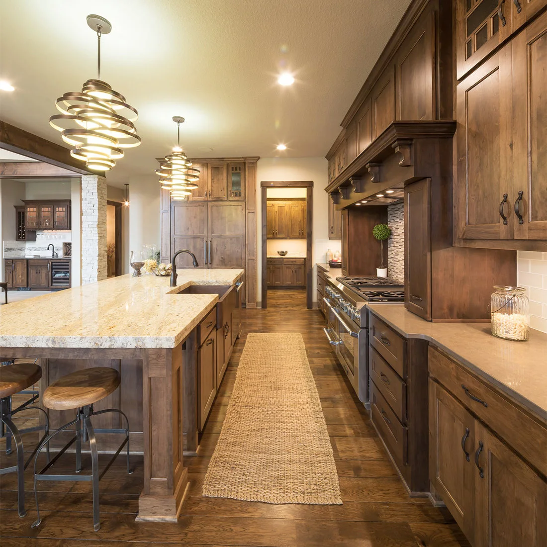 A long timber kitchen aisle with a woven runner, island sink and pale worktops