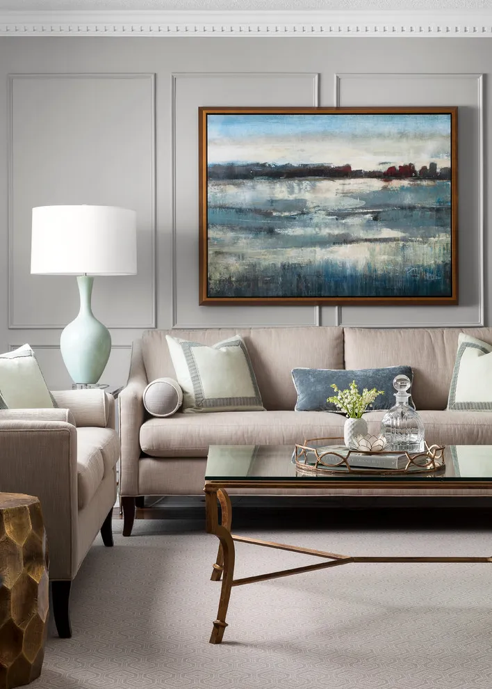 Coastal painting above a beige sofa with blue cushions