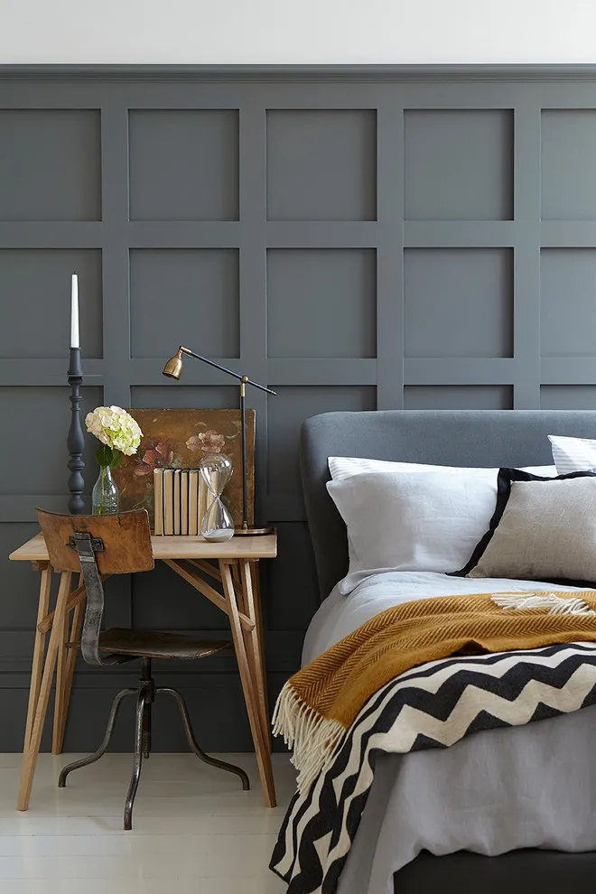 Dark gray rectangular panels sit behind a bed with mustard accents