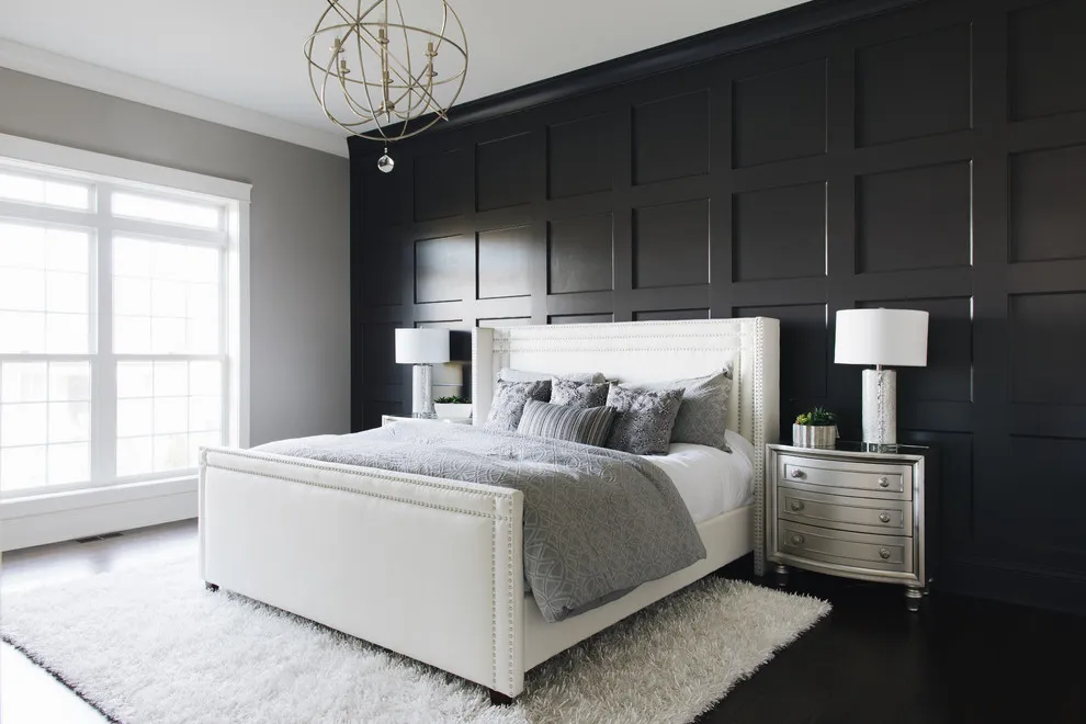 A pale upholstered bed sits against a black paneled wall beside bright windows