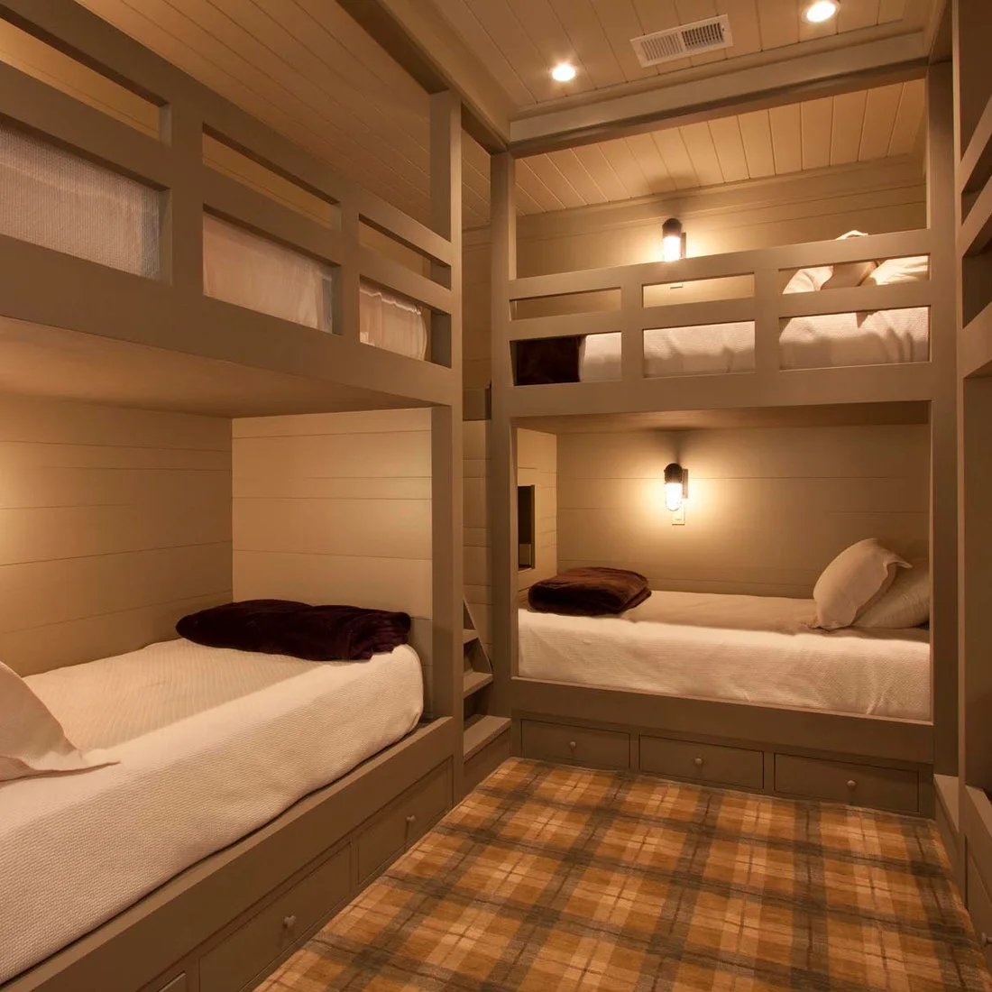 Four built in sleeping bunks with painted paneling, individual wall lights and underbed drawers