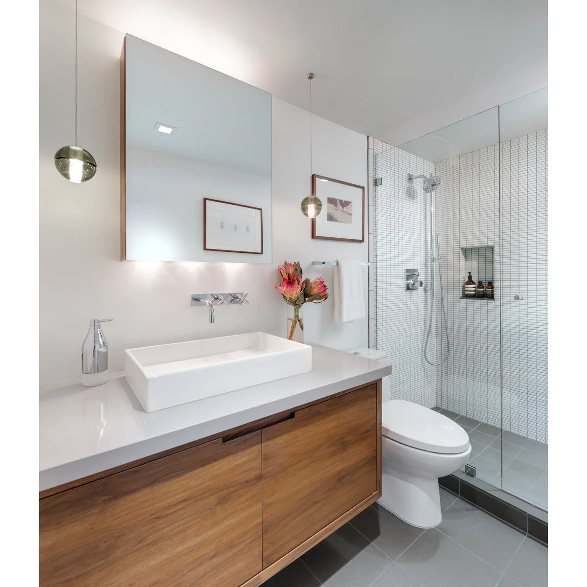 Compact bathroom with a floating wood vanity, wall-mounted toilet and clear glass shower enclosure