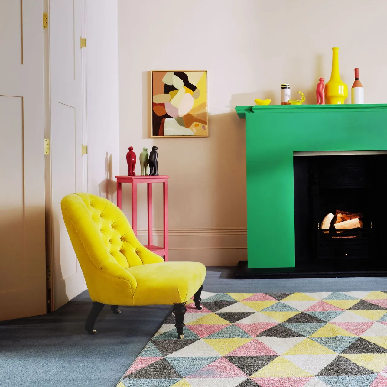 A bright green fireplace surround stands beside a yellow chair above a multicolored geometric rug.
